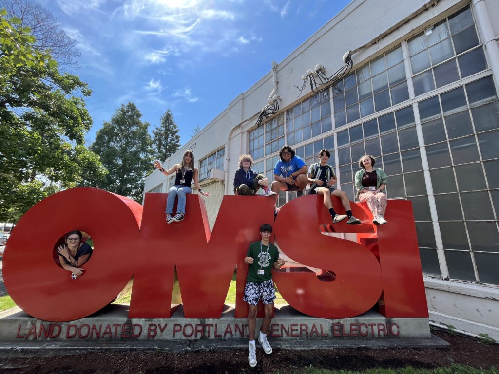 YouthCARE members at OMSI sign