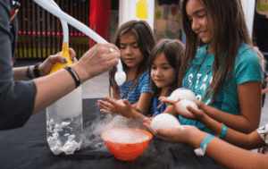 Three students participating in a hands on lab at the Oregon Museum of Science and Industry.
