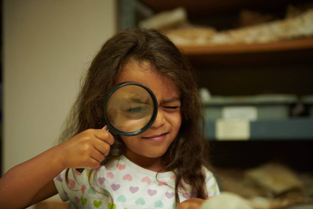 Girl with magnifying glass.