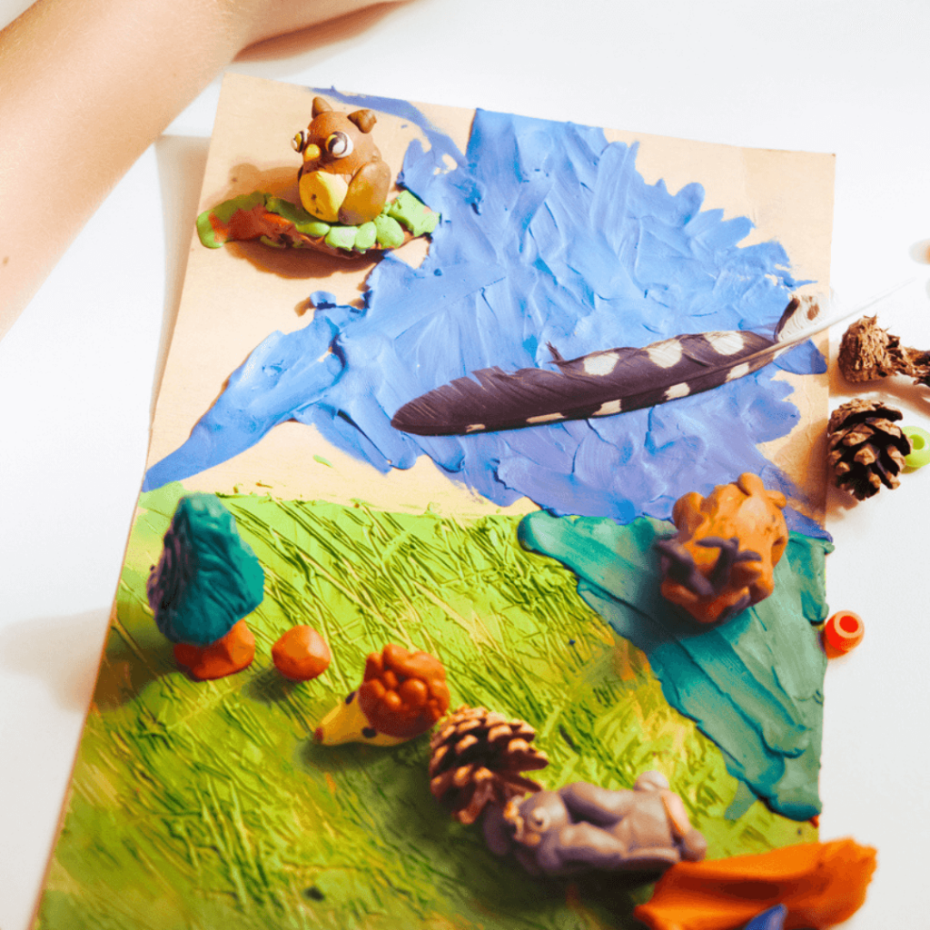 Diorama floor made with feathers, pinecones, clay, and paint