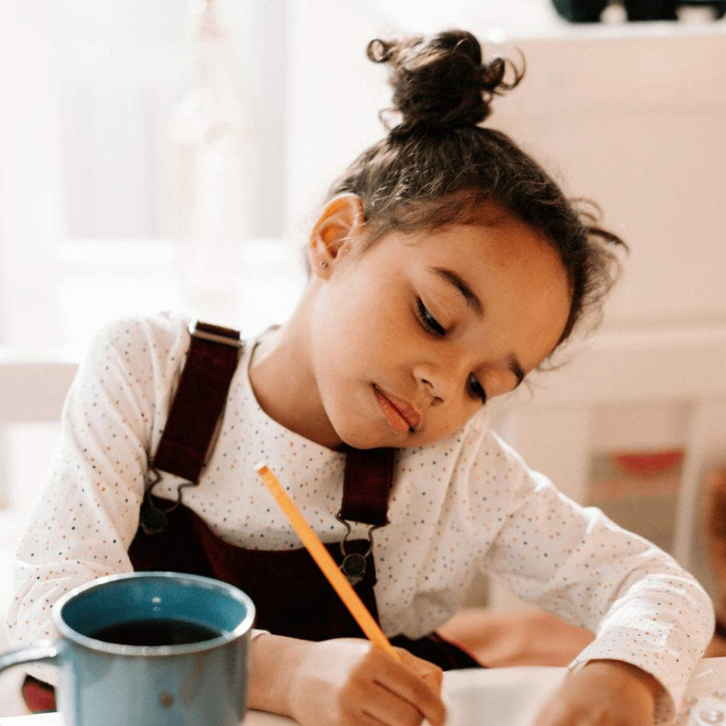 Young girl writing ideas down on a piece of paper
