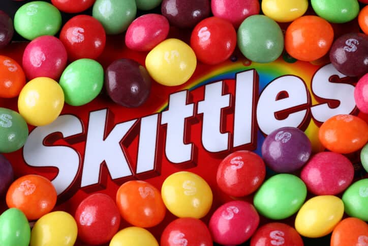 Skittles logo covered in loose skittles candy
