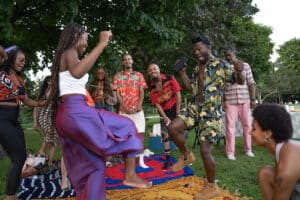 Group of people dancing and celebrating Juneteenth at a picnic in a park