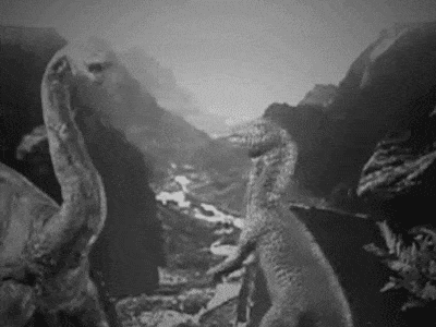 Gif of dinosaurs attacking each other in a black and white stop motion film