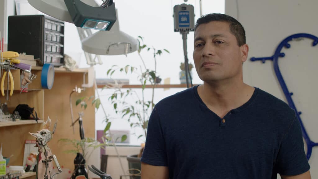 Photo of a man wearing a blue shirt at his desk, an employee at ShadowMachine