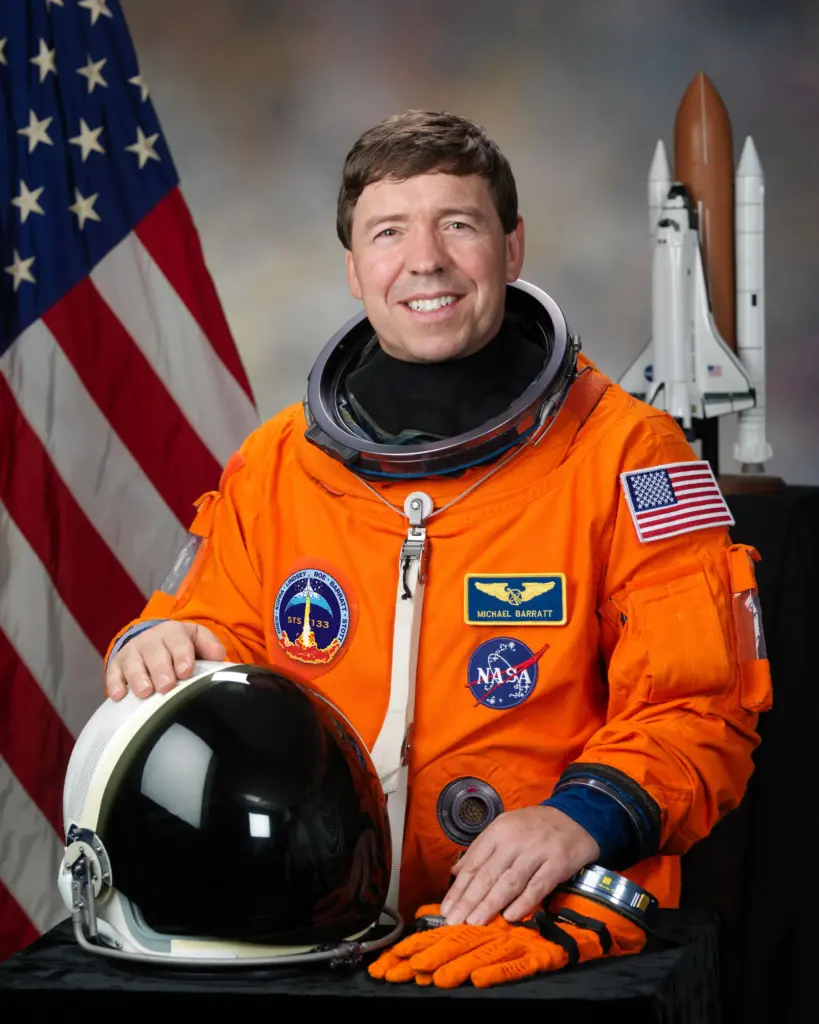 Dr. Michael Barrett, an astronaut currently on the International Space Station and a former OMSI kid, poses in his space suit for his official astronaut photo.