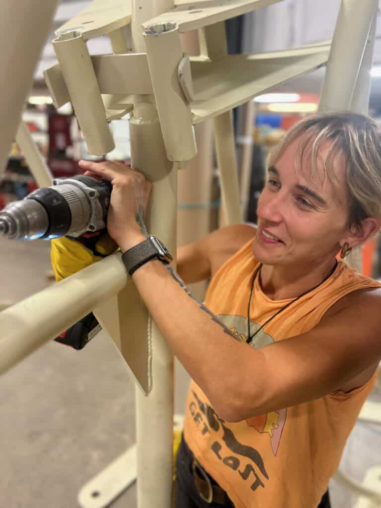 Migrations artist, Olivia Pheonix, working on the sculpture frame