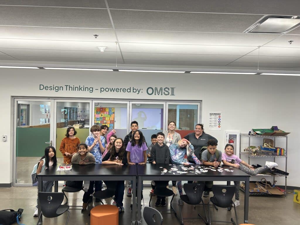 A class of older elementary students at Tamarack Elementary pose in the OMSI Lab at their school.