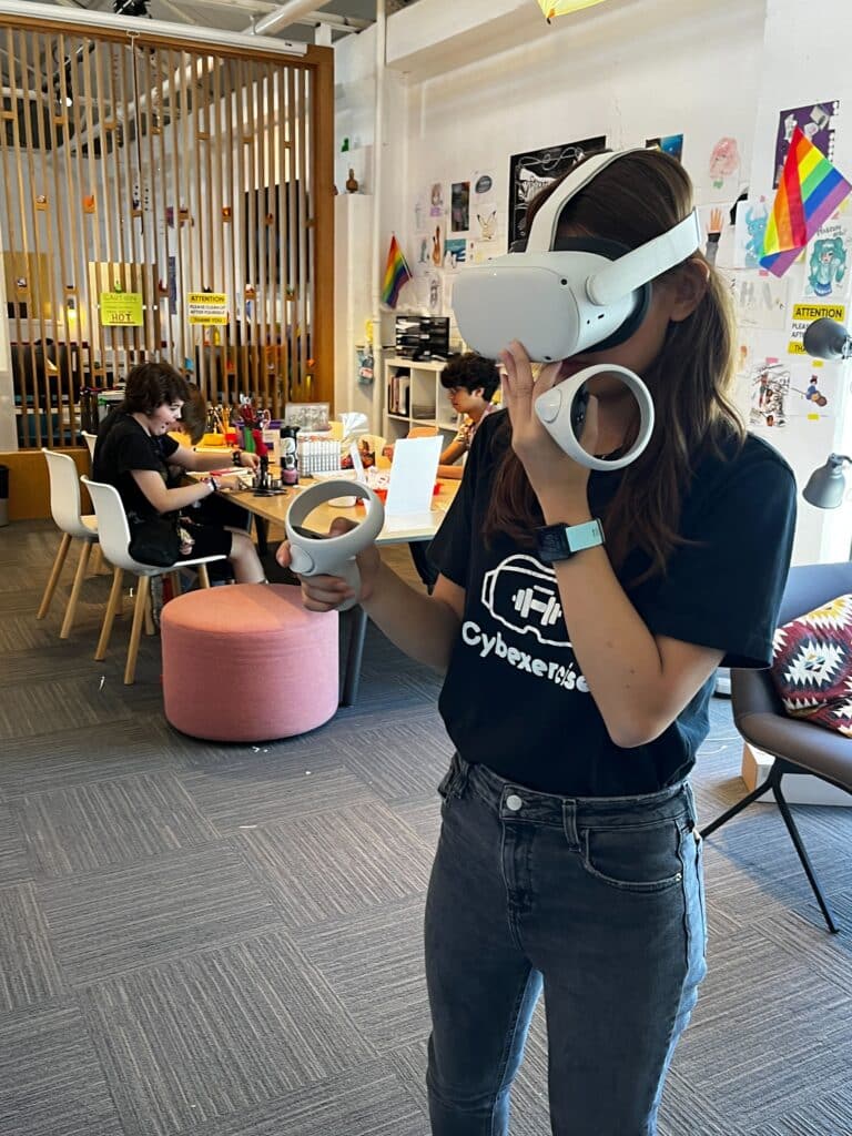 Teen Tech Center intern Ashley Tran demonstrates how to use a virtual reality headset