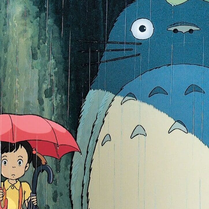 Totoro and Satsuki holding an umbrella at a bus stop on a rainy day. Studio Ghibili's film, My Neighbor Totoro, cover art. OMSI Studio Ghibli Film Fest 2024