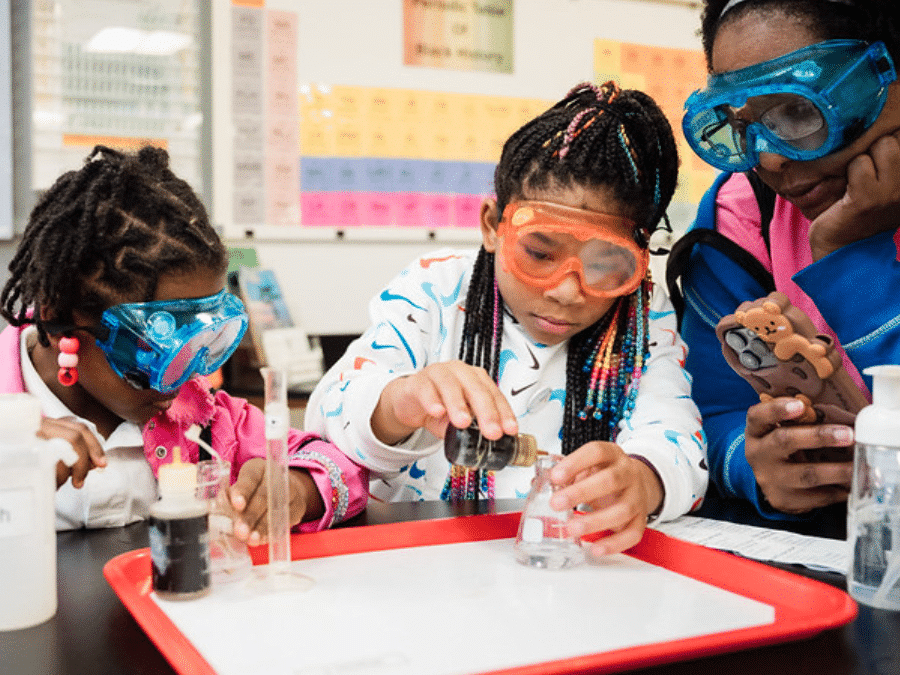 Picture of two girls in goggles doing an experiment at Black Community Science Night