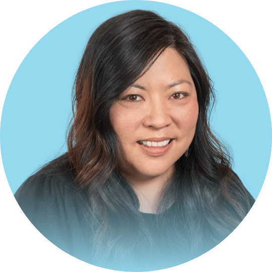 Headshot of a woman with long black hair wearing a black sweater
