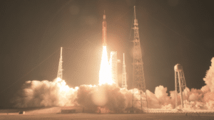 Rocket taking off in the dark with a plume of smoke and fire beneath it