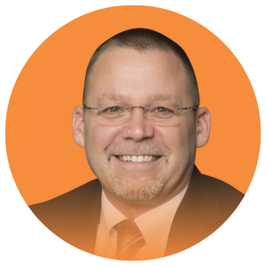 Headshot of a man in a suit wearing glasses