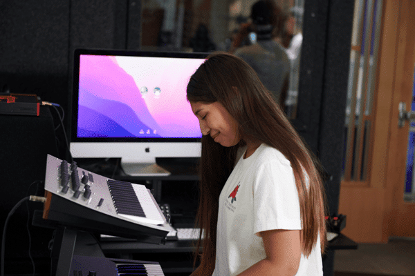 Teen using the piano keyboard in the Teen Tech Center
