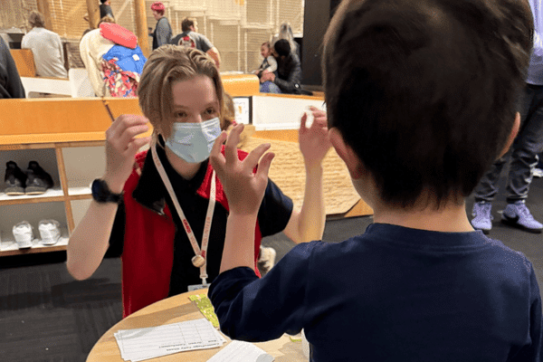 Teen volunteer working with a child in OMSI's science playground