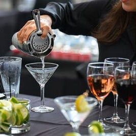 A bartender pouring a martini out of a shaker at the OMSI gala