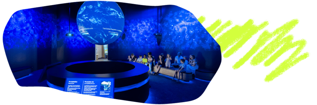 An image of Science on a Sphere at OMSI with several families sitting and watching it. The image border is an organic shape, similar to a long oval and there is a yellow brush stroke behind it